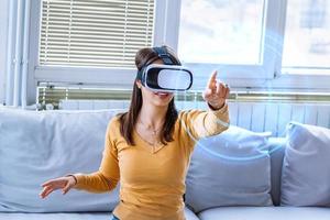 jeune femme faisant l'expérience de la technologie de réalité virtuelle immersive portant des lunettes vr, interagissant avec l'interface utilisateur du casque à 360 degrés, choisissant des produits lors de ses achats, sélectionne le contenu dans le menu de jeu 3d photo
