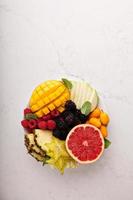 assiette de fruits avec mangue, pamplemousse et baies photo