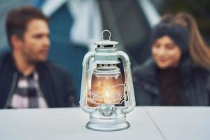 jeune couple sympa s'amusant en camping avec lampe à pétrole photo