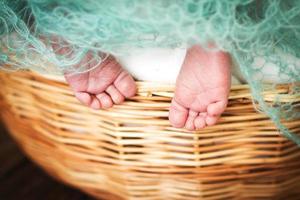 pieds de bébé nouveau-né. jambes d'enfants dans le panier en osier photo