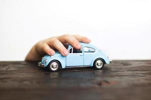 Enfant jouant avec la voiture à proximité sur un fond blanc photo