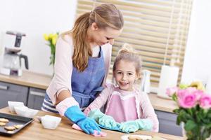 petite fille et sa maman en tabliers nettoyant la cuisine photo