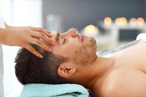 bel homme ayant un massage dans un salon de spa photo