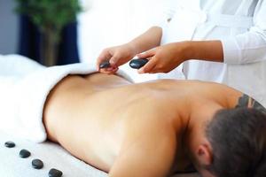 bel homme ayant un massage dans un salon de spa photo