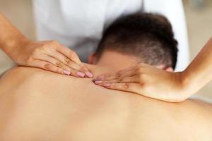 bel homme ayant un massage dans un salon de spa photo