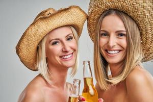 filles faisant la fête avec des chapeaux et des boissons grillées photo