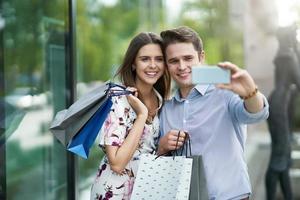 portrait d'un couple heureux avec des sacs à provisions en ville souriant et étreignant. photo