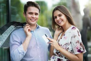 portrait d'un couple heureux avec des sacs à provisions en ville souriant et étreignant. photo