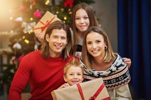belle famille avec des cadeaux sur l'arbre de Noël photo