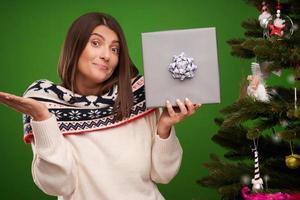 femme heureuse adulte avec un cadeau de noël sur fond vert photo