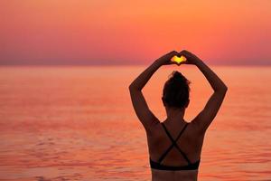 jeune femme nageant dans la mer au lever du soleil photo