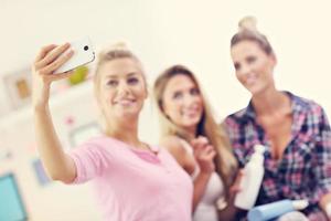 trois belles jeunes femmes qui se détendent à la maison et prennent un selfie photo