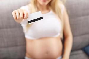 femme enceinte utilisant une tablette et une carte de crédit à la maison photo