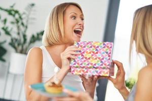 belles deux filles adultes dans la maison avec un gâteau d'anniversaire photo