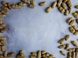 macro de cacahuètes ouvertes en studio, fond de texture de mur blanc photo