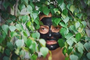 jeune femme dans la nature avec un masque noir sur le visage photo