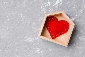 vue de dessus du coeur textile rouge dans une maison en bois sur fond de ciment. concept de maison douce maison. La Saint-Valentin photo