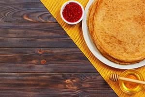 crêpes chaudes saupoudrées de sirop d'érable et de confiture de framboises. le bon petit déjeuner. vue de dessus photo