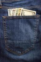billets en dollars dans la poche de jeans agrandi. notion d'entreprise. argent de poche. photo