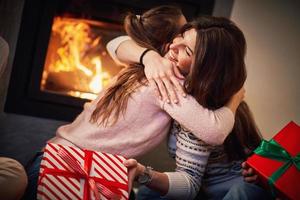 Girl friends échangeant des cadeaux de Noël au-dessus de la cheminée photo