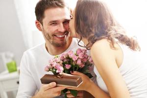 homme donnant des fleurs et cadeau à une femme au lit photo