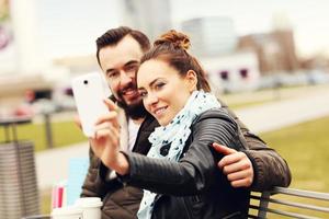 jeune couple avec sacs à provisions et smartphone photo