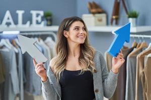 jeune fille sympa avec des flèches dans un magasin de vêtements photo