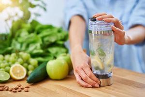 femme adulte en bonne santé avec de la nourriture verte dans la cuisine photo