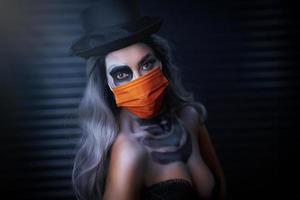 portrait effrayant de femme en maquillage gothique halloween portant un masque de protection photo