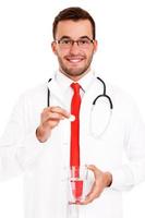 médecin tenant une pilule et un verre d'eau photo