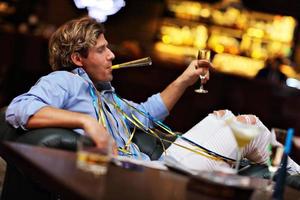 jeune homme assis seul au bar avec un verre de whisky photo