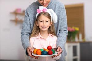 mère et fille peignant des oeufs de pâques à la maison photo