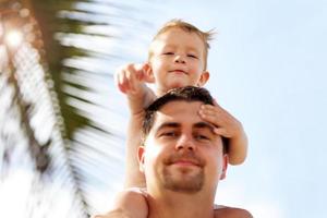 père s'amusant sur la plage avec son petit fils photo