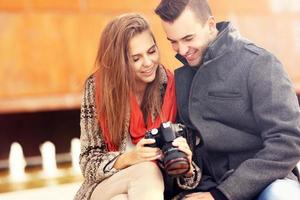 jeune couple vérifiant les photos sur leur appareil photo