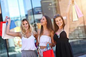 Happy girl friends shopping dans le centre commercial photo