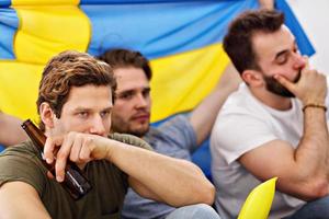 heureux amis masculins acclamant et regardant le sport à la télévision photo