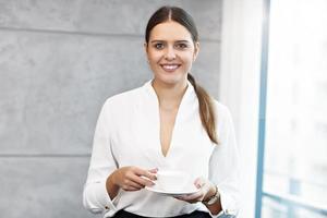 portrait en gros plan d'une jolie femme d'affaires souriante sur le lieu de travail photo