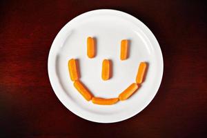 Sourire de carotte sur plaque blanche photo