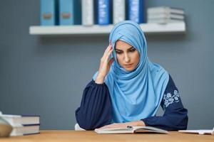 Malheureuse étudiante musulmane apprenant à la maison photo