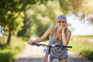 jeune femme heureuse sur un vélo à la campagne photo
