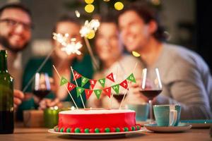 groupe d'amis célébrant noël à la maison avec un gâteau de fantaisie photo