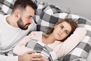 couple attrayant adulte au lit ayant un problème photo