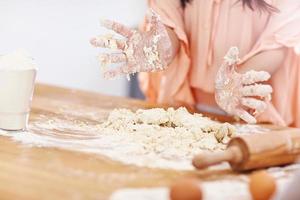 jeune femme essayant de faire du pierogi dans la cuisine photo