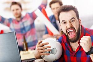 heureux amis masculins acclamant et regardant le sport à la télévision photo