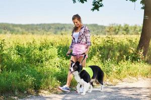 portrait d'une femme heureuse promenant son chien à loisir photo