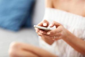 femme heureuse se détendre à la maison avec un smartphone photo