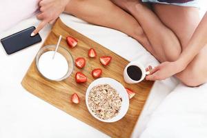 jeune femme au lit avec petit déjeuner photo