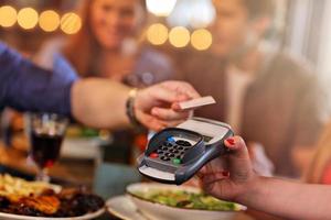 groupe d'amis payant un repas au restaurant photo