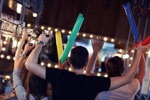 groupe d'amis regardant le football dans un pub photo