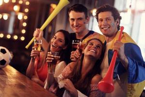 groupe d'amis regardant le football dans un pub photo